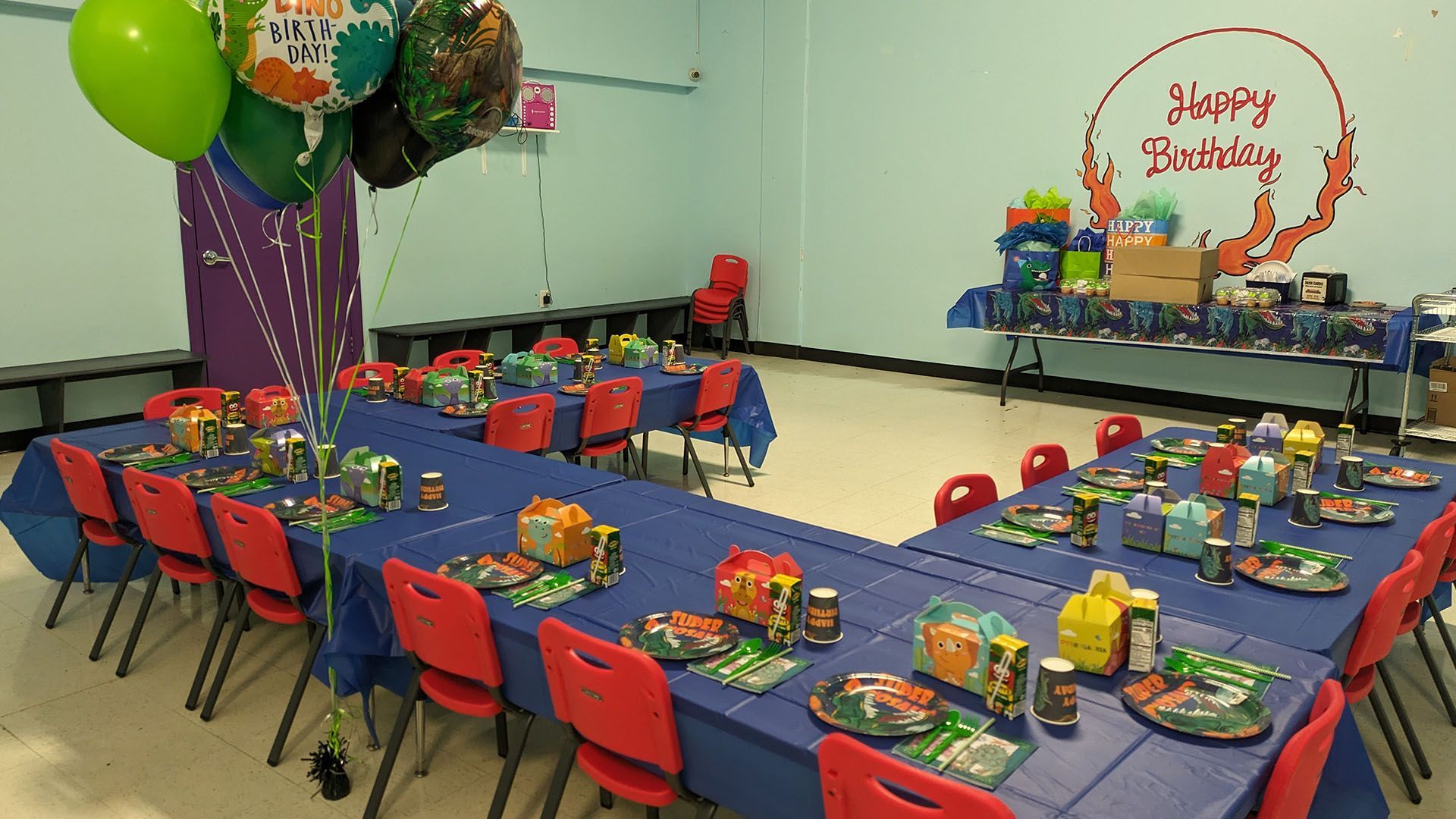 A room with tables and chairs set up for a birthday party