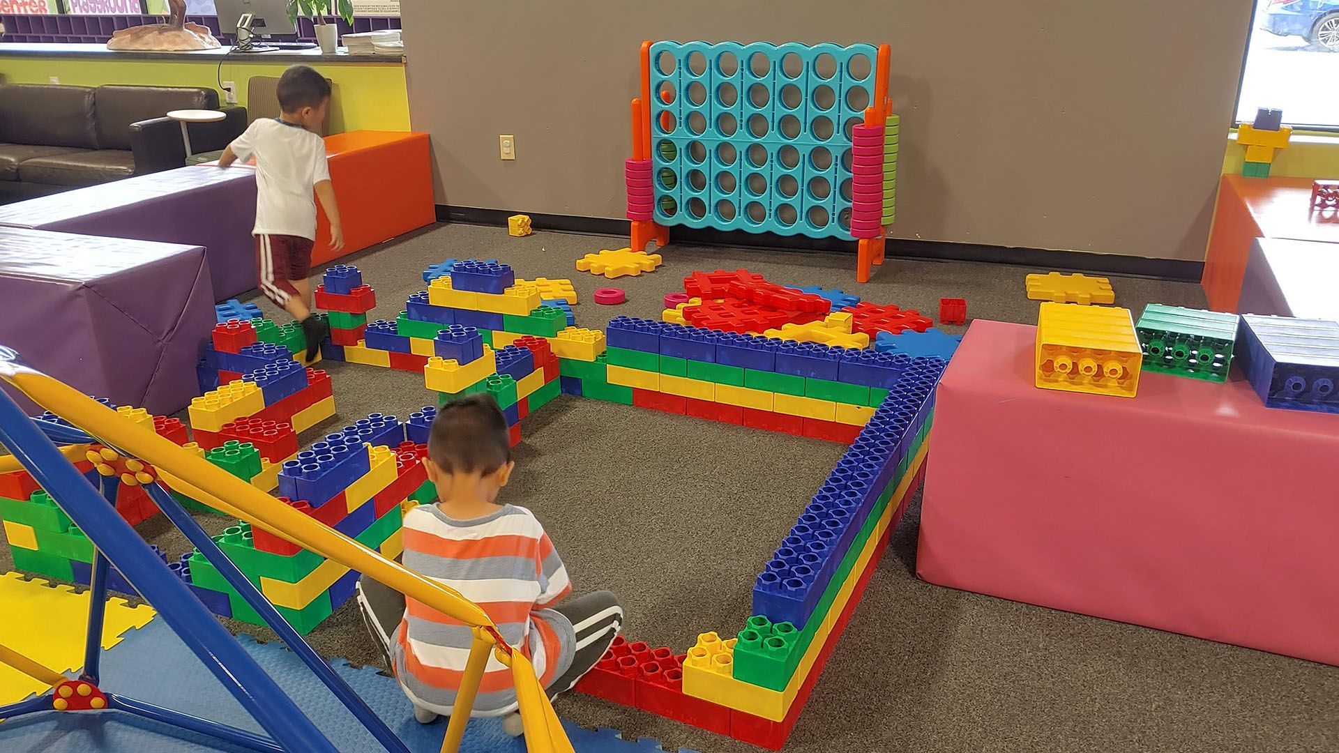 A child is playing with a bunch of toys in a room.