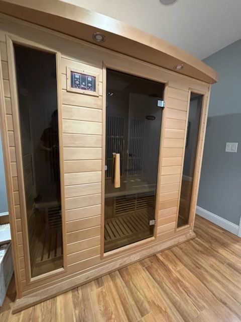 A wooden sauna in a room with a wooden floor