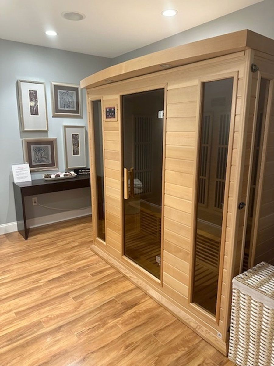 A wooden sauna is sitting in a room with hardwood floors