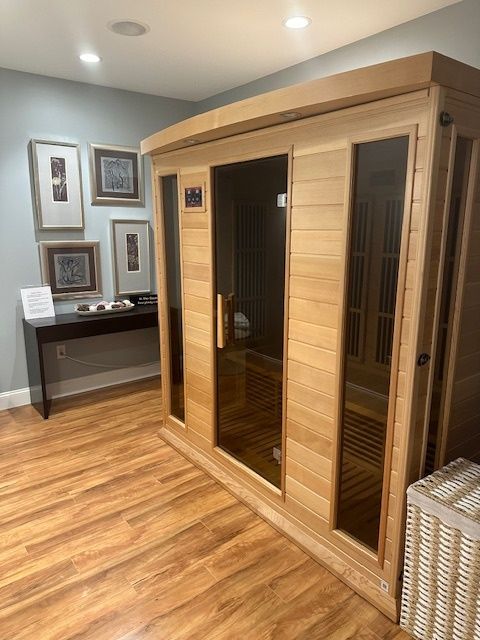 A wooden sauna is sitting in a room with hardwood floors.