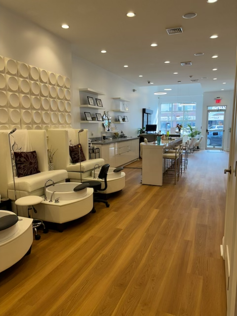 A nail salon with wooden floors and white furniture
