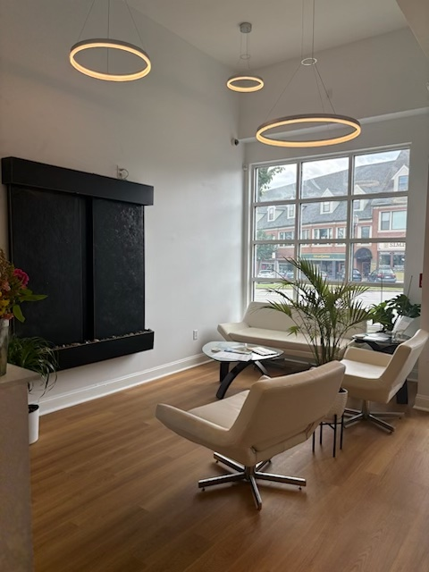 A living room with chairs a table and a fireplace