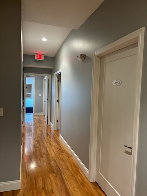 A hallway with a red exit sign on the ceiling