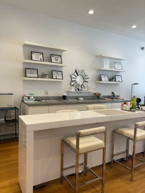 A kitchen with a white counter top and stools