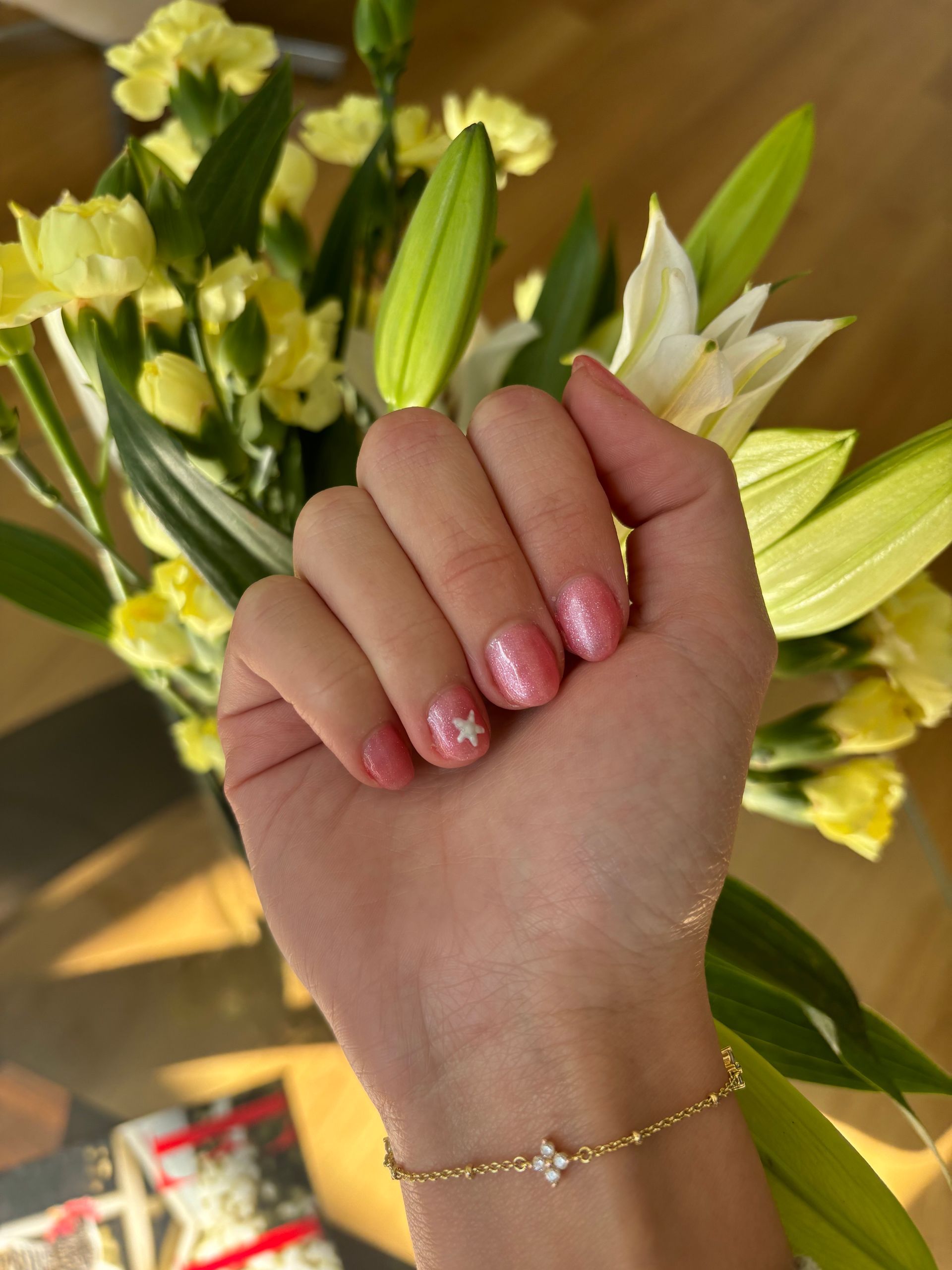 A woman 's hand is holding a bouquet of yellow and white flowers