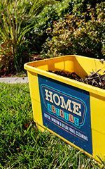 Yellow garden bin with HOME DEPOT logo in a landscaped yard