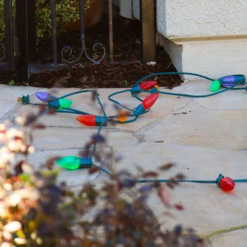 Tangling string of colorful Christmas lights on a porch near a doorway