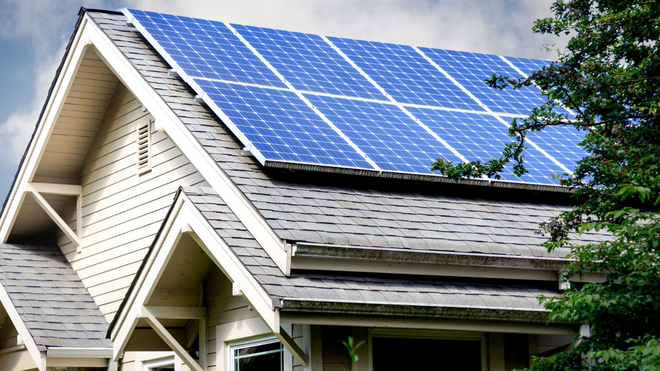 House roof with blue solar panels installed on a sunny day