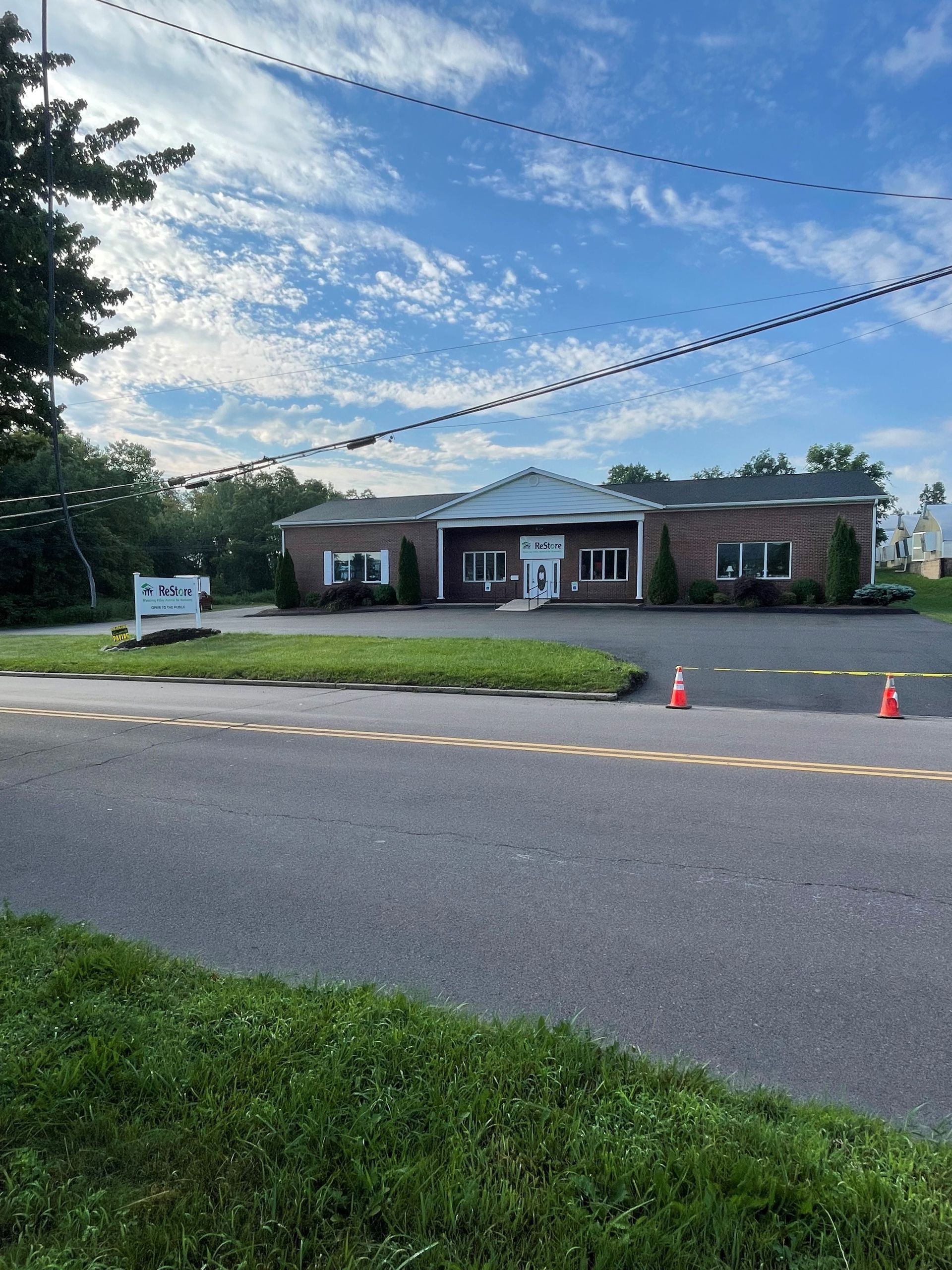 A large brick building is sitting on the side of an asphalt road.