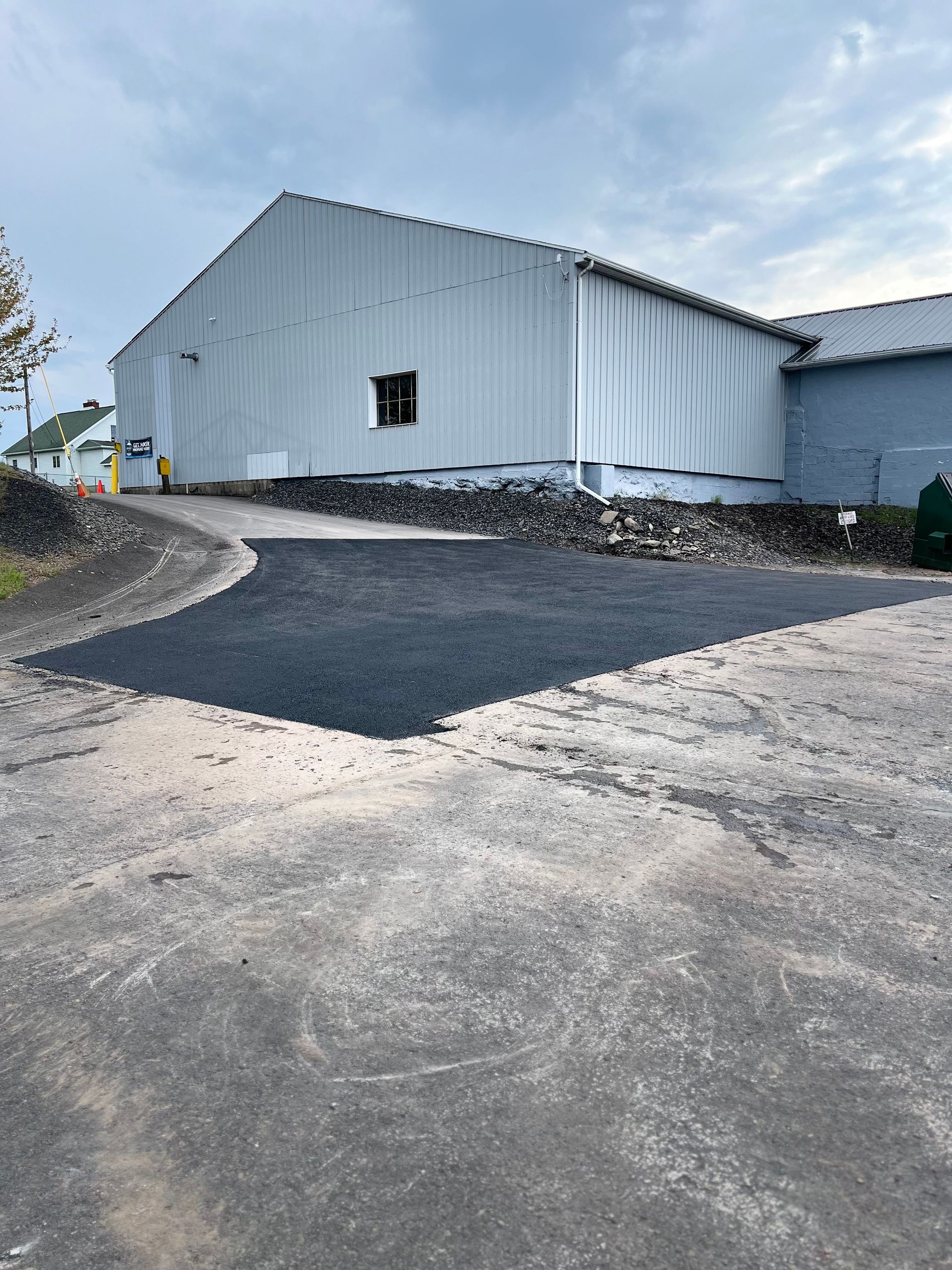 A large white building with a concrete driveway in front of it.