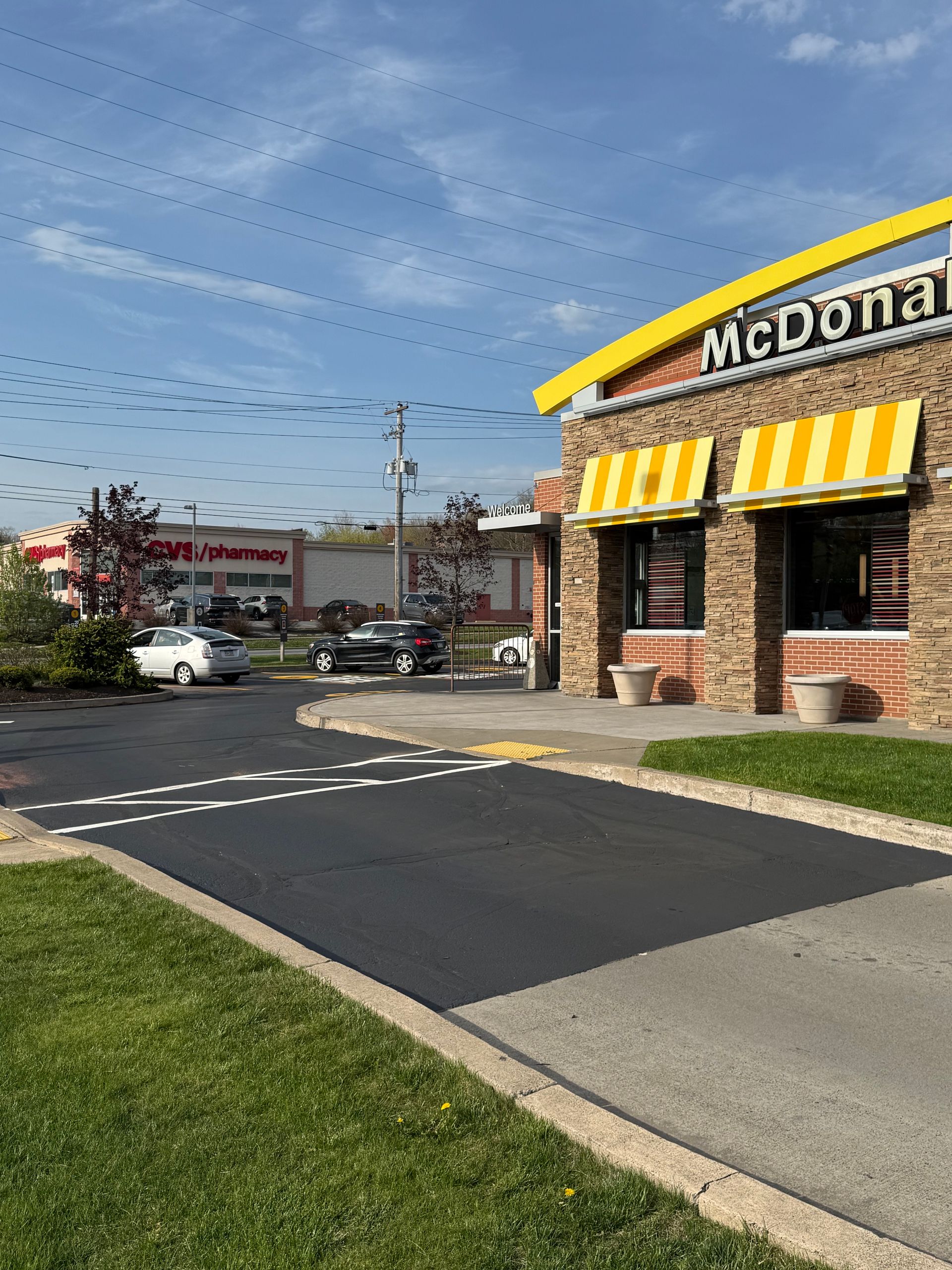 A McDonald's restaurant with a lot of cars parked in front of it.