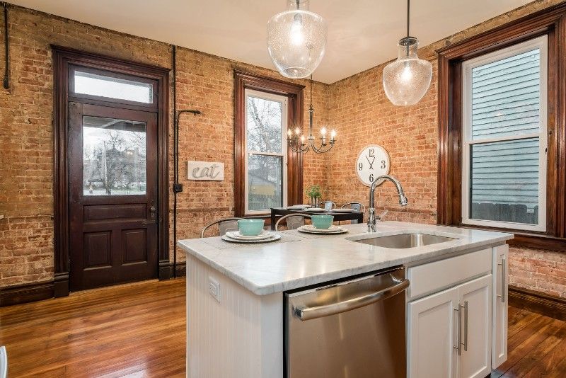 A kitchen with a large island , sink , and dishwasher.