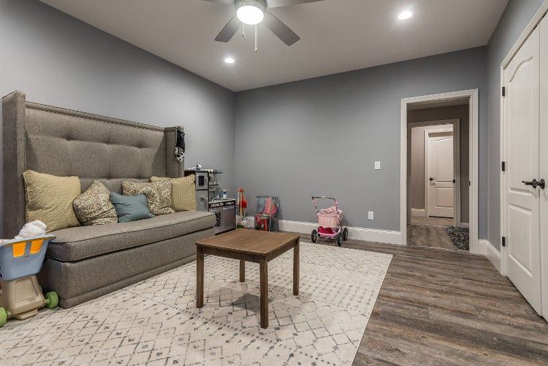 A living room with a couch , table , and ceiling fan.