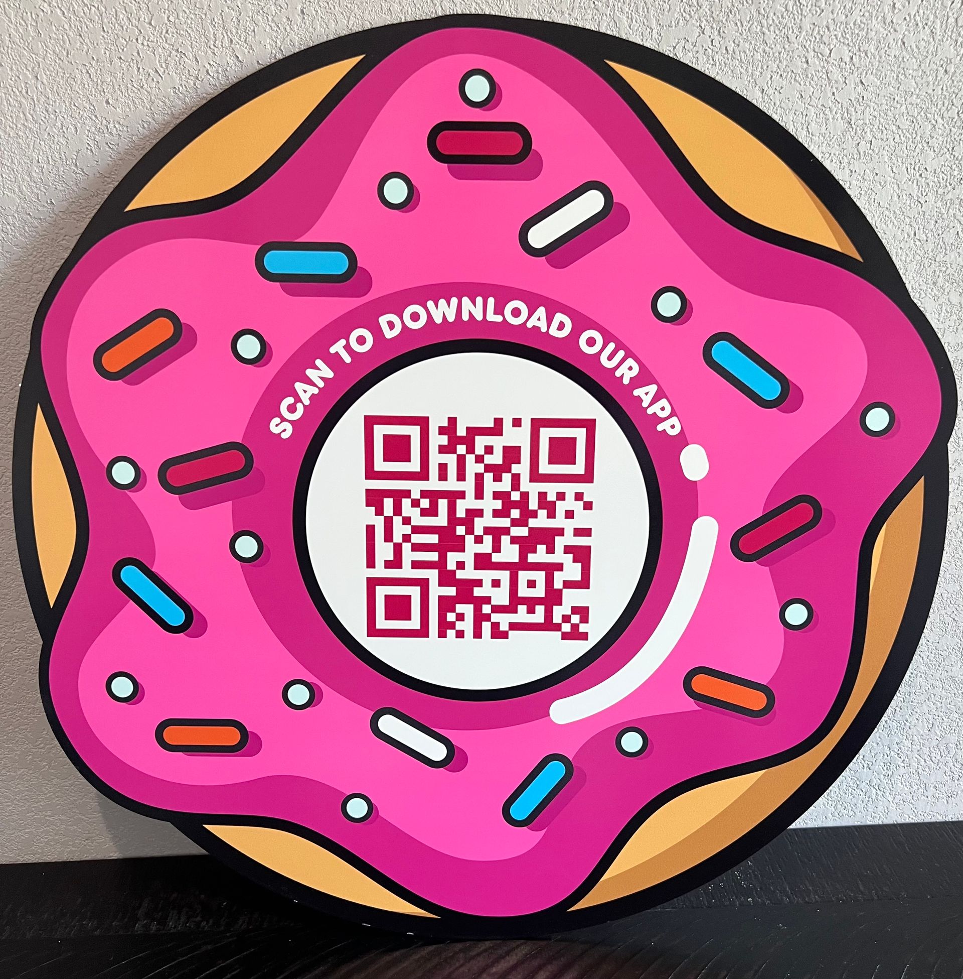 A pink donut that says scan to download our app