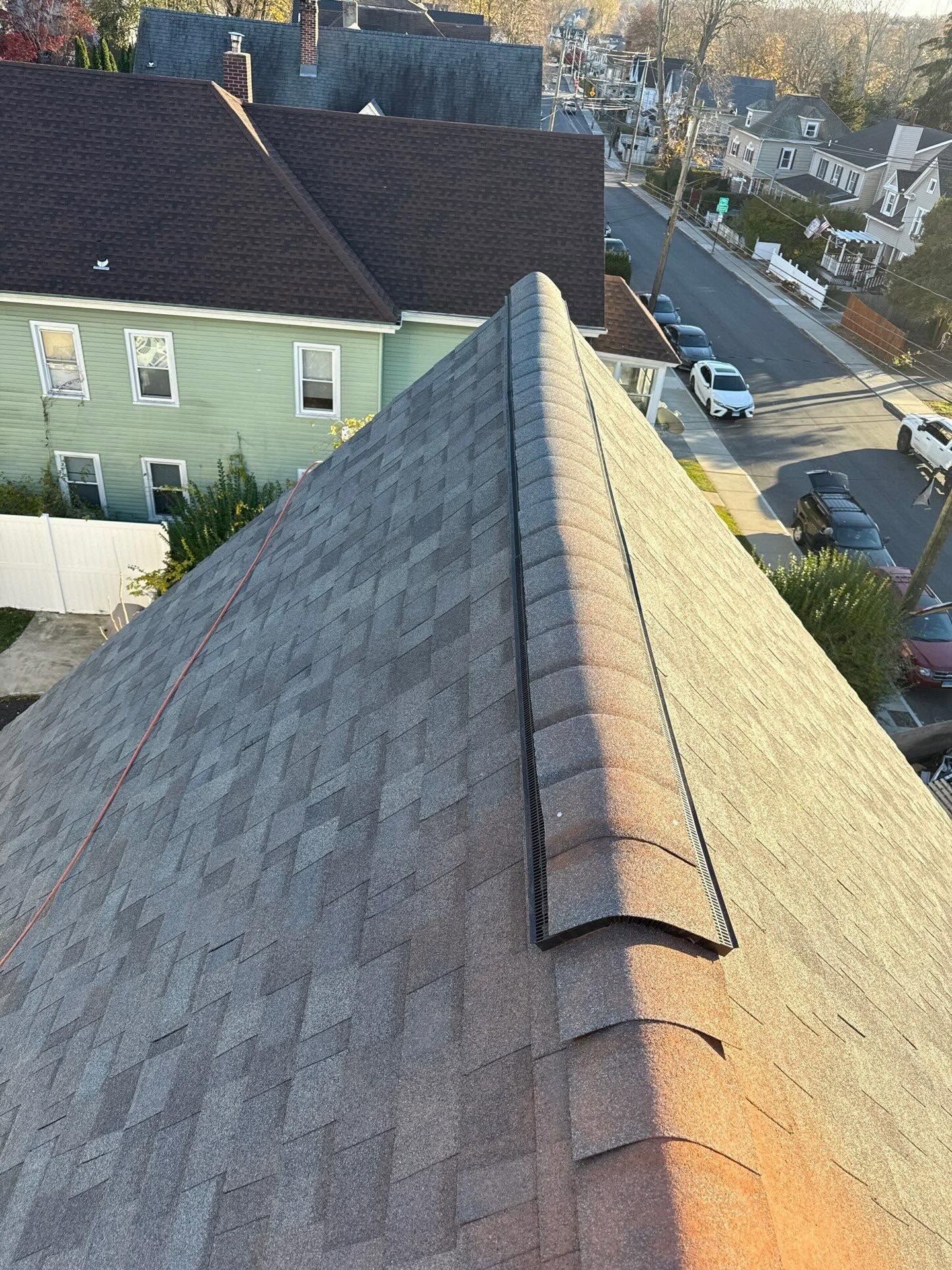 Roof ridge at sunset overlooking a residential street and houses
