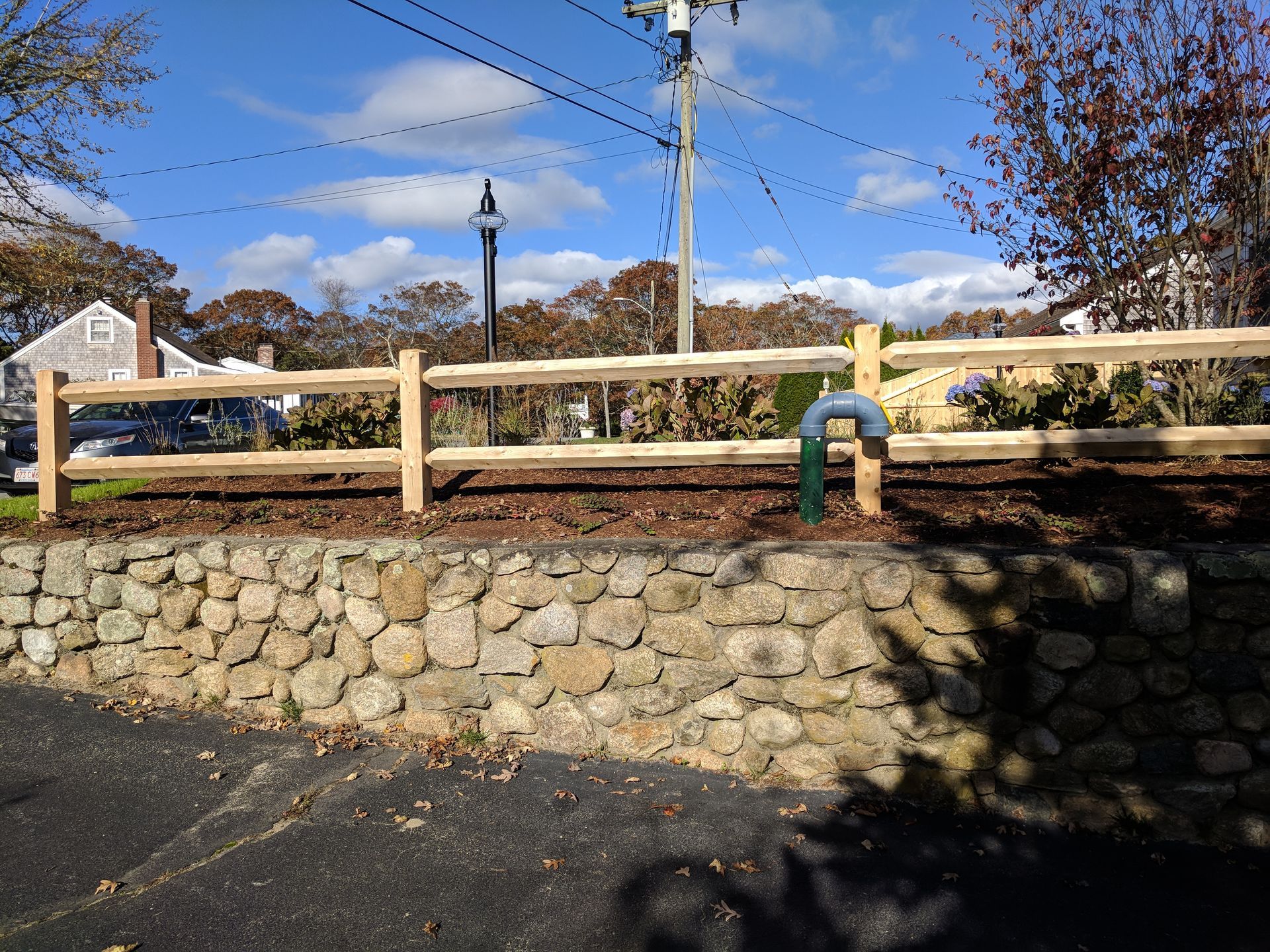 A stone wall with a wooden fence in front of it