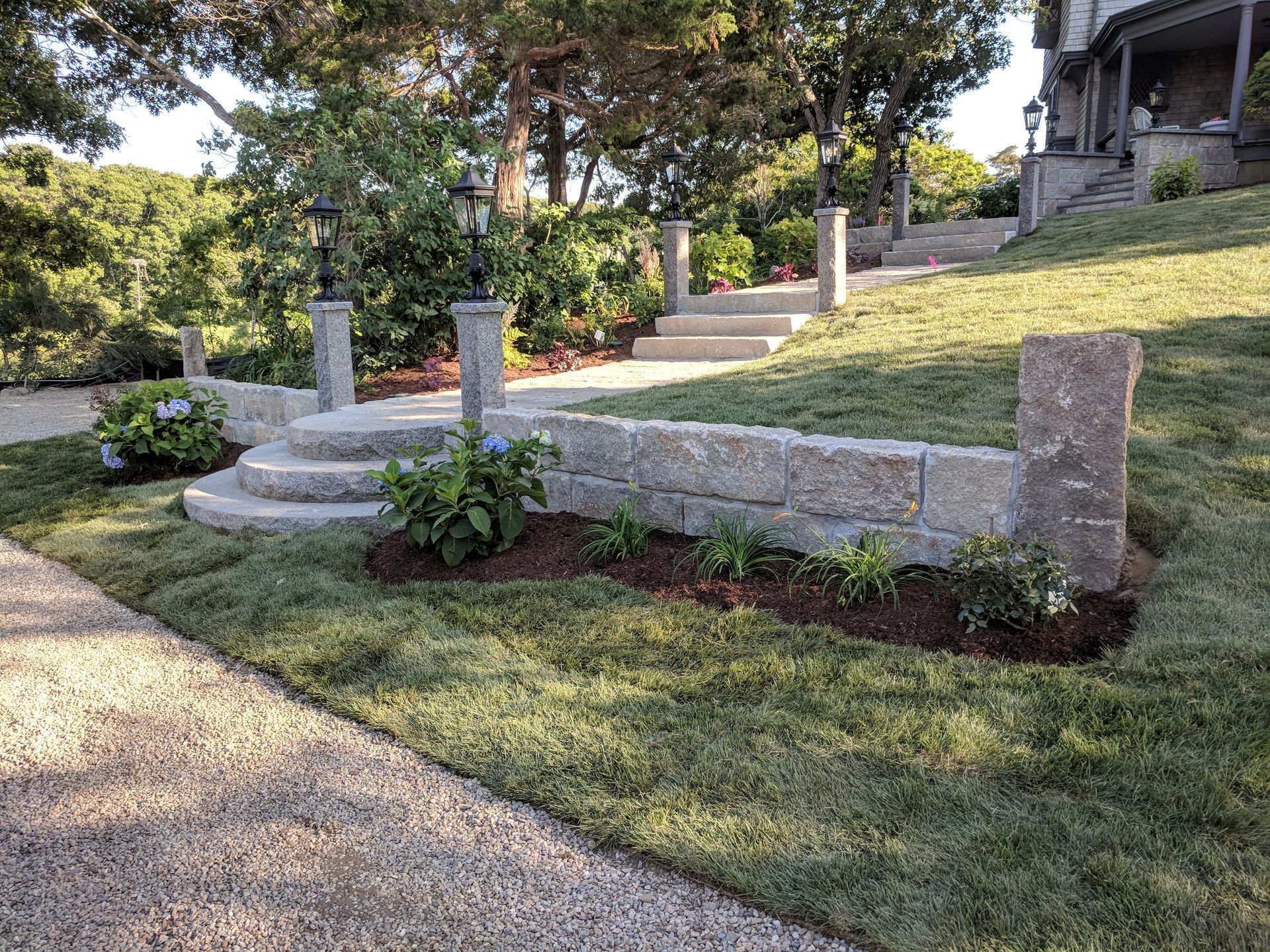 A stone wall with steps leading up to a house.