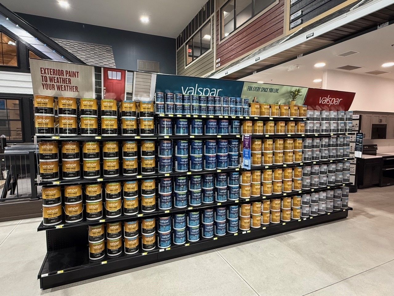 Shelves of paint cans in a store; various brands and colors displayed.