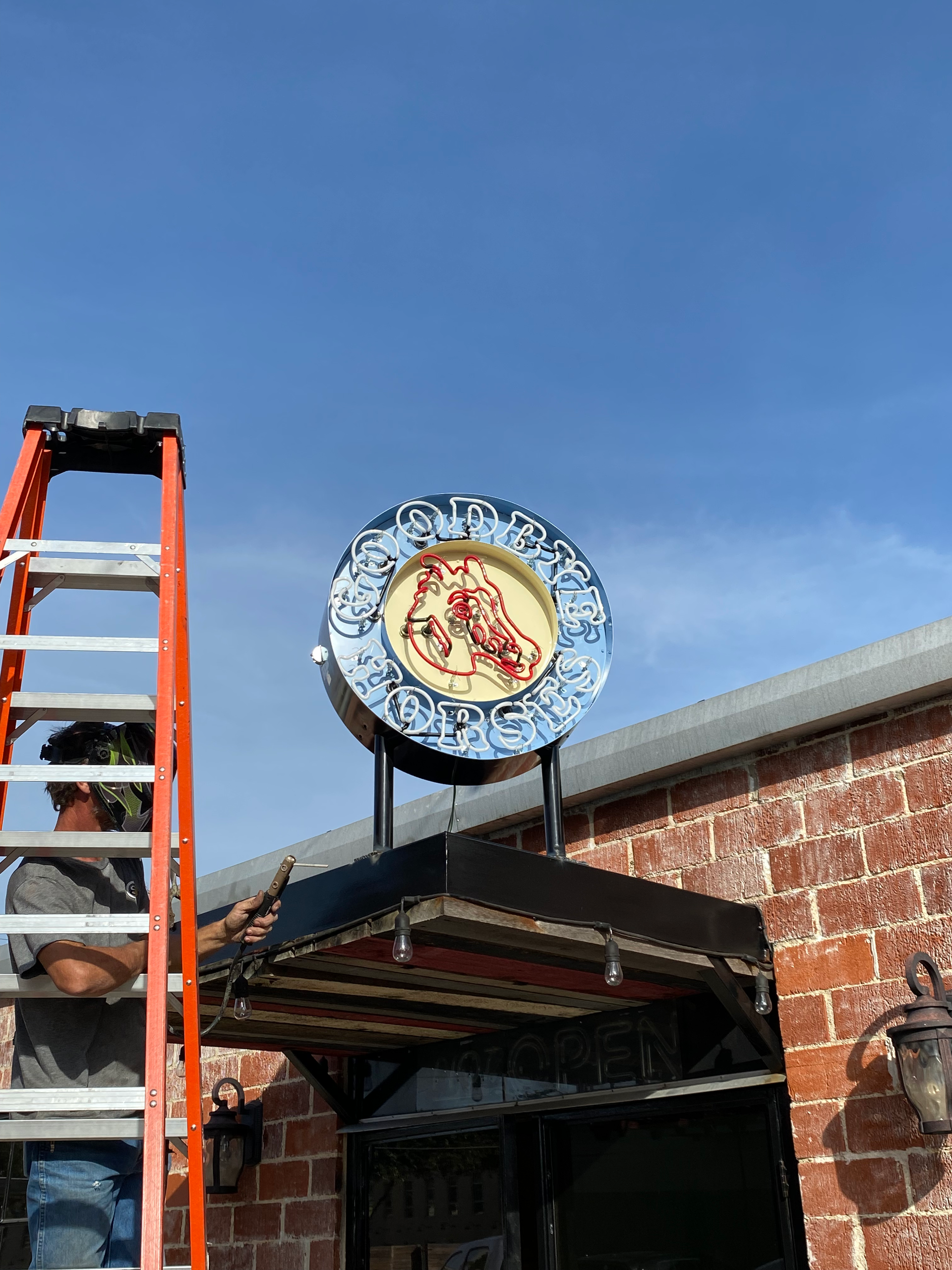 A crane is lifting a large red and white sign
