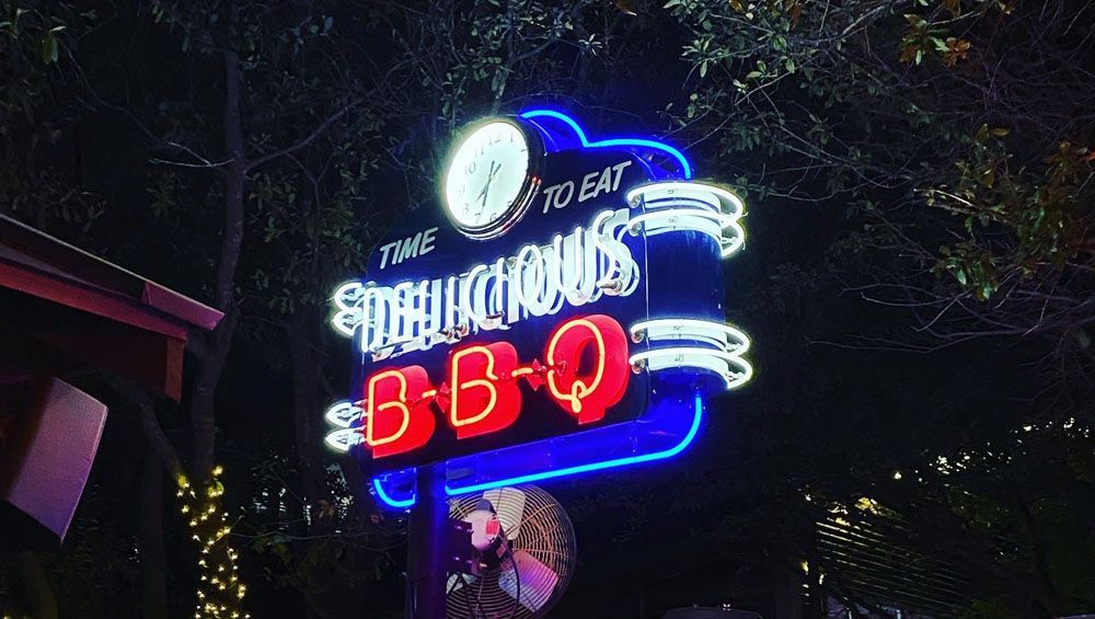 A neon sign for a restaurant is lit up at night