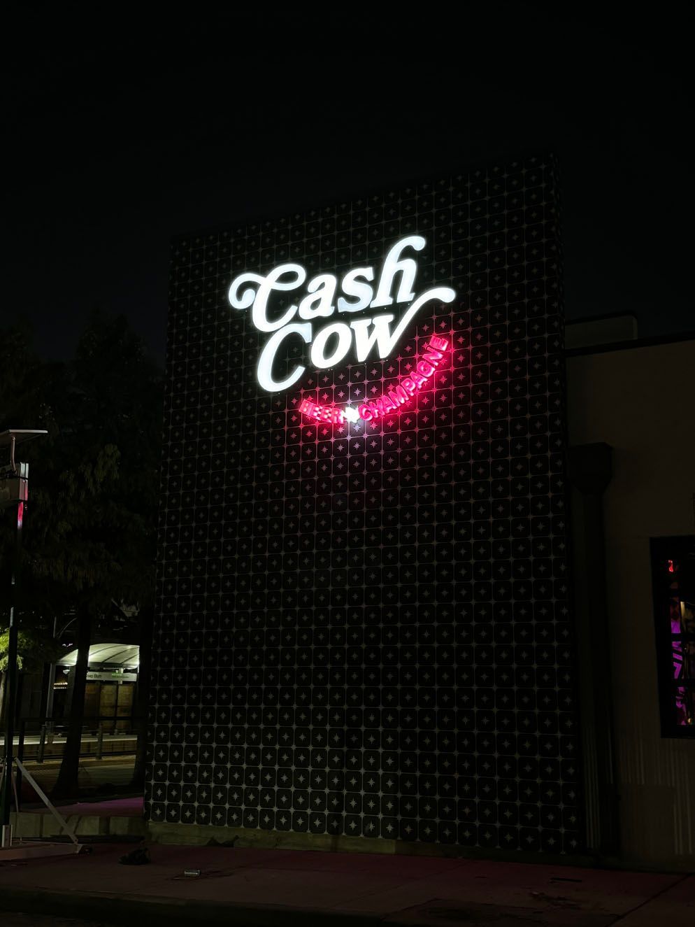 A neon sign for cash cow is lit up at night
