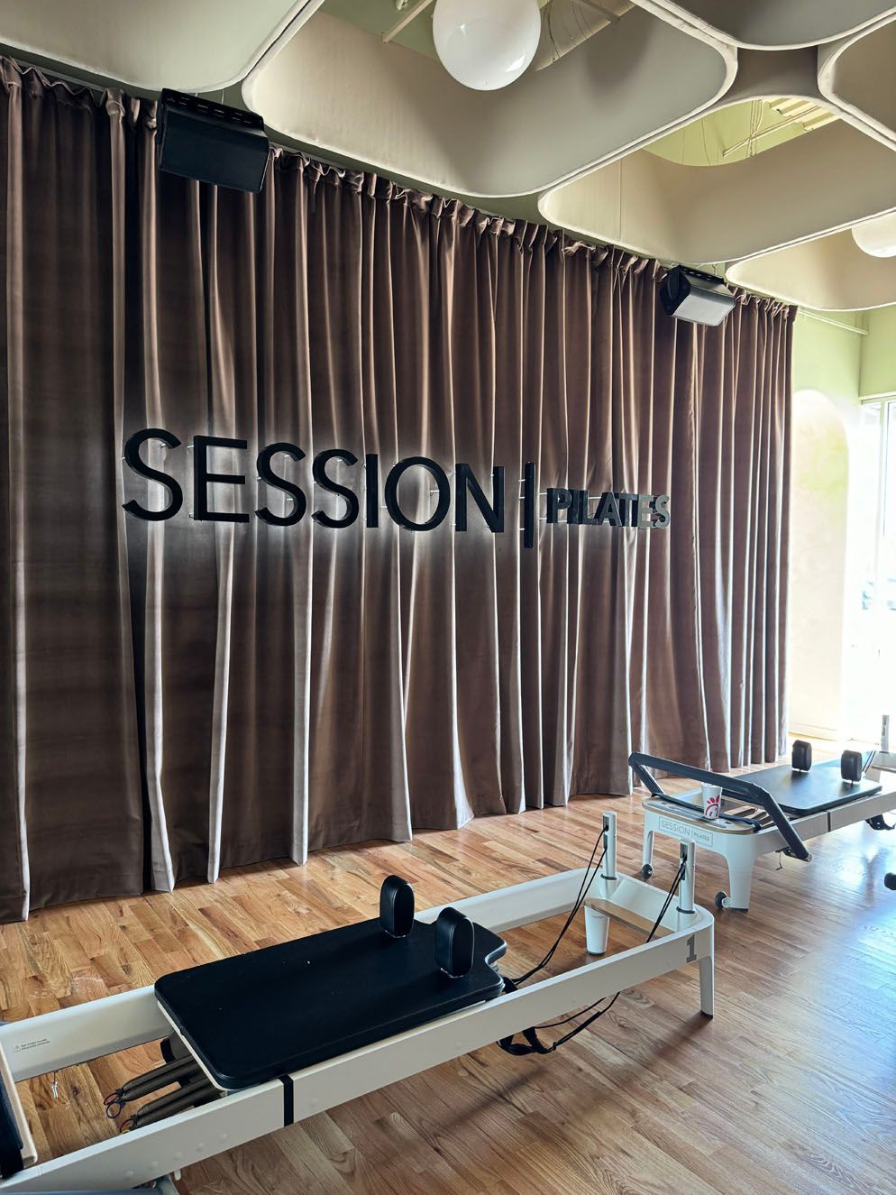 A room with a pilates machine and a sign that says session pilates