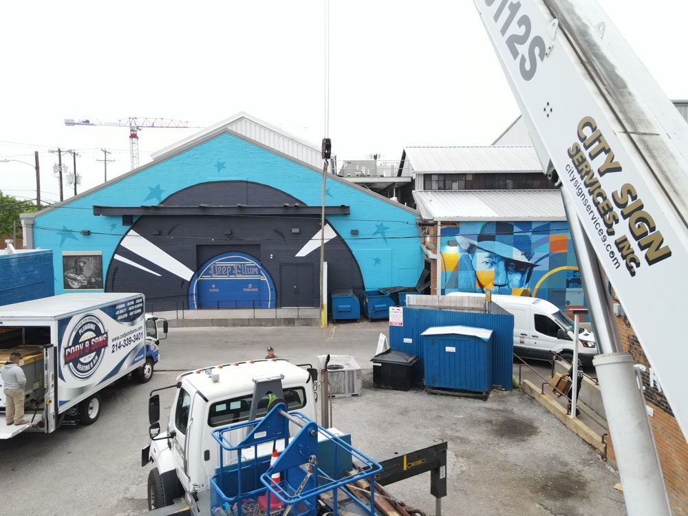 A white truck is parked in front of a blue building