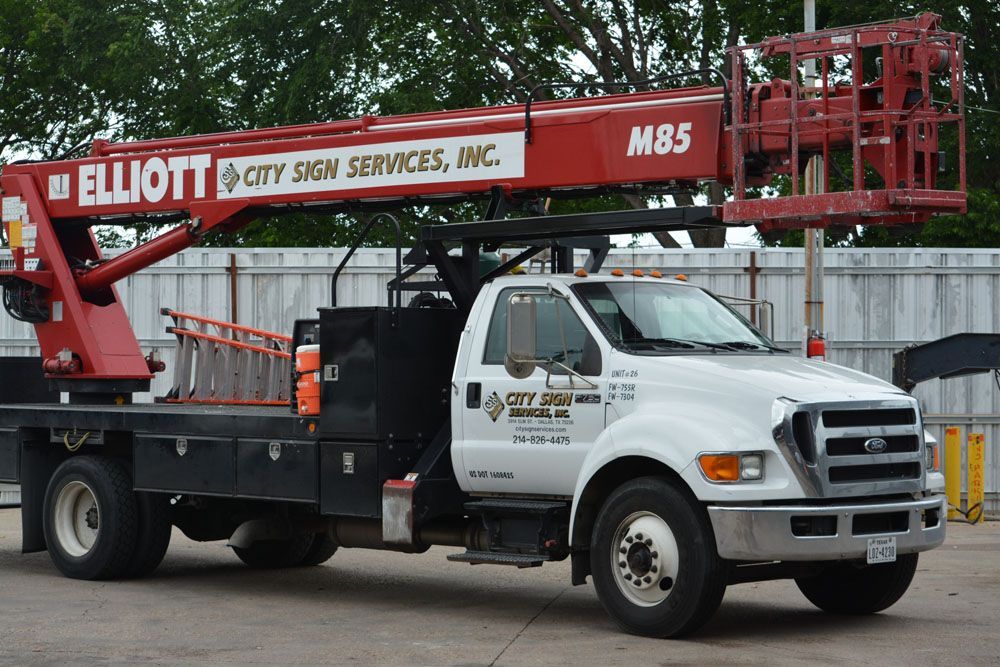 A red and white elliott sign services truck