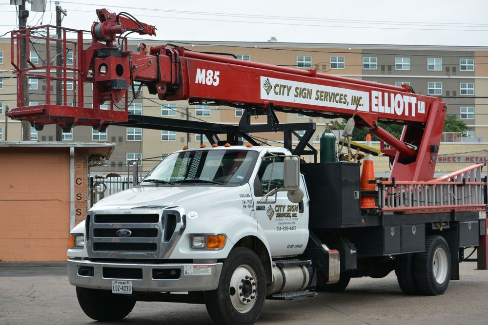 A white truck with a red crane on top of it