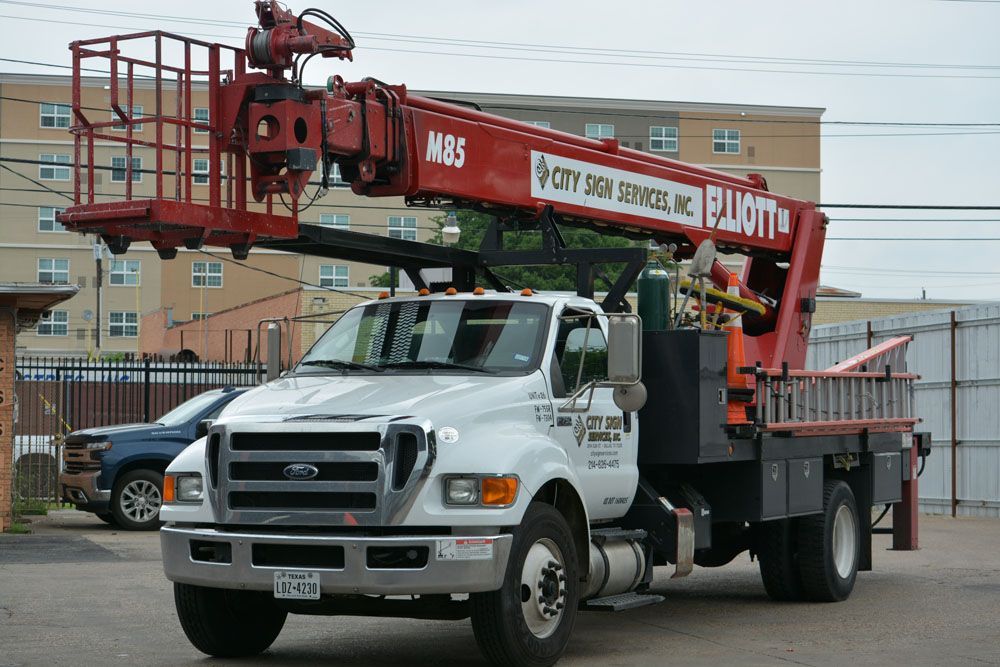 A white truck with a red crane on top of it