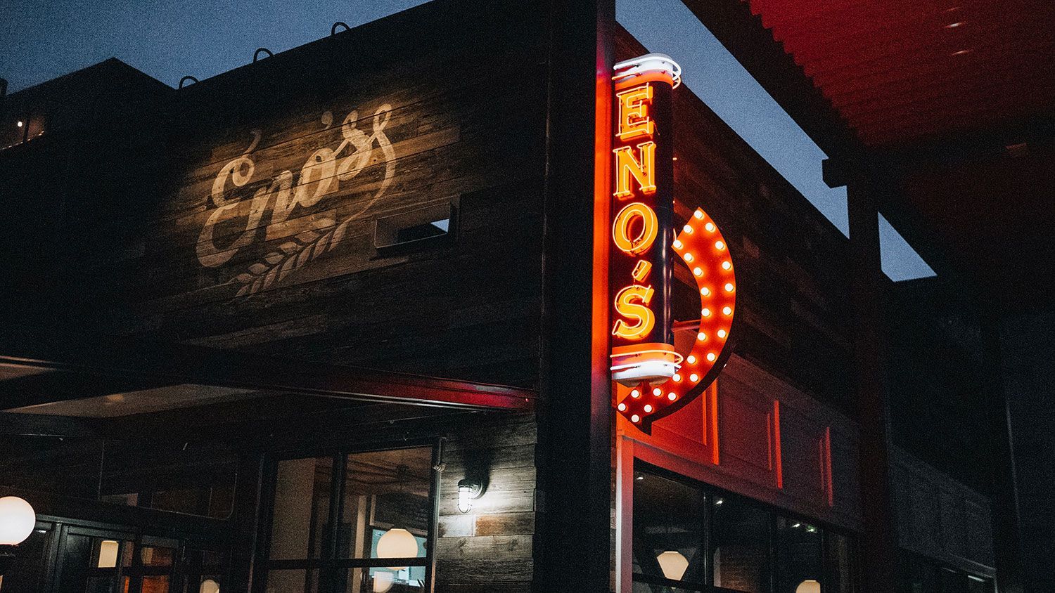 A restaurant with a neon sign that says Enzo's on it