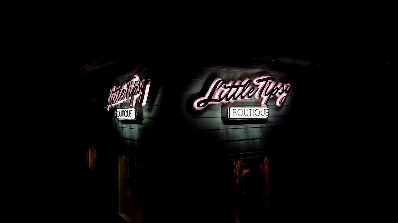 A neon sign for a restaurant is lit up at night.