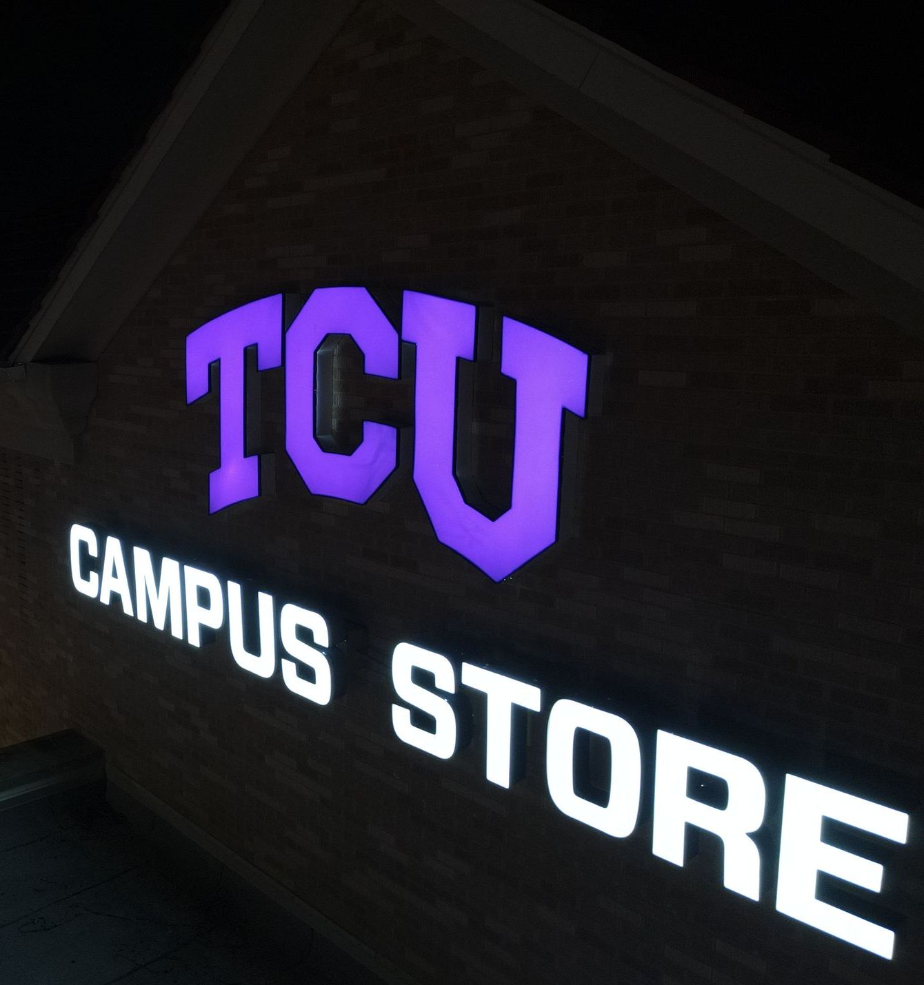 A Baldwin sign is lit up at night on the side of a building