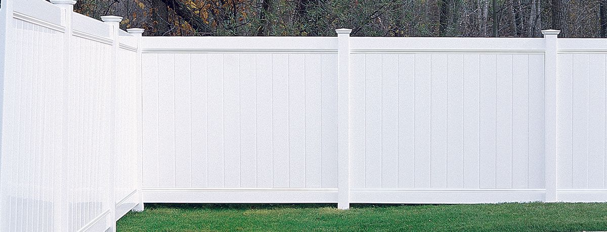 A white house with a white fence in front of it.