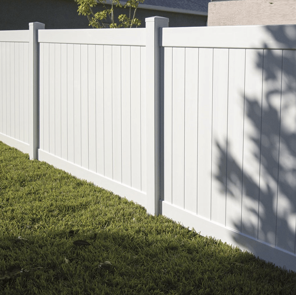 A white fence surrounds a lush green yard