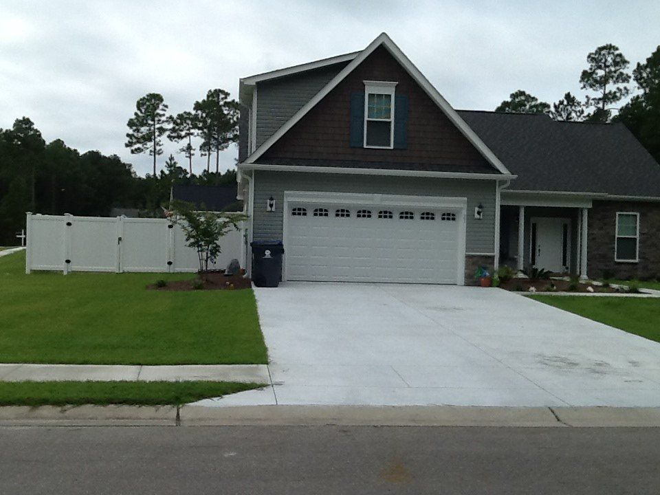 A house with a white garage door and a white fence