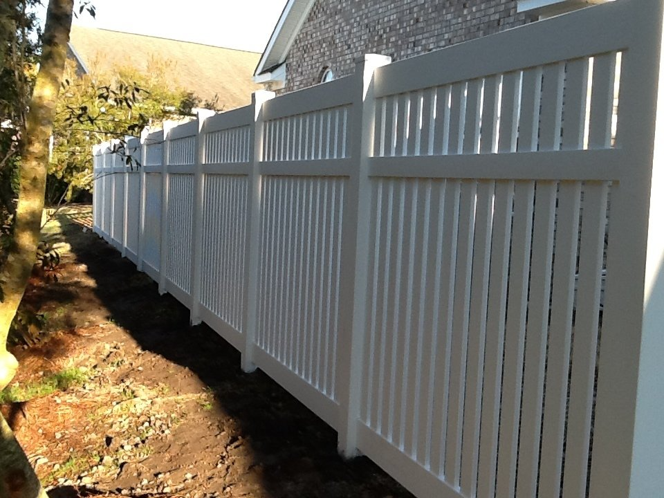 A white fence with a house in the background