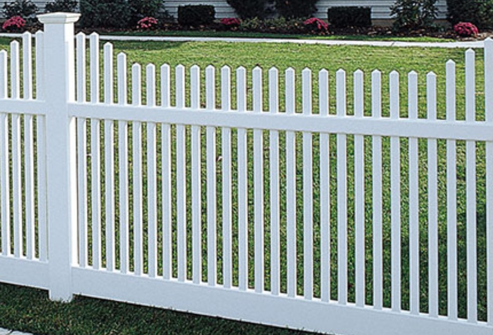 A white picket fence surrounds a lush green yard