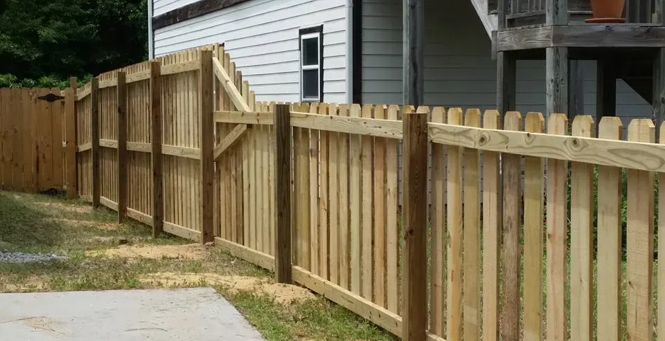 A wooden fence is sitting in front of a house.