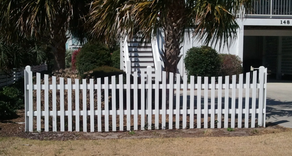 A white fence is sitting in the middle of a field.