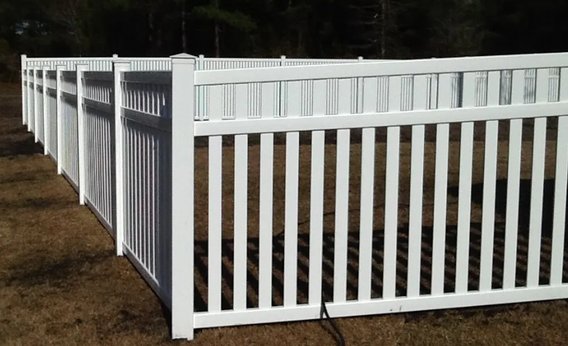 A white fence is sitting in the middle of a field.