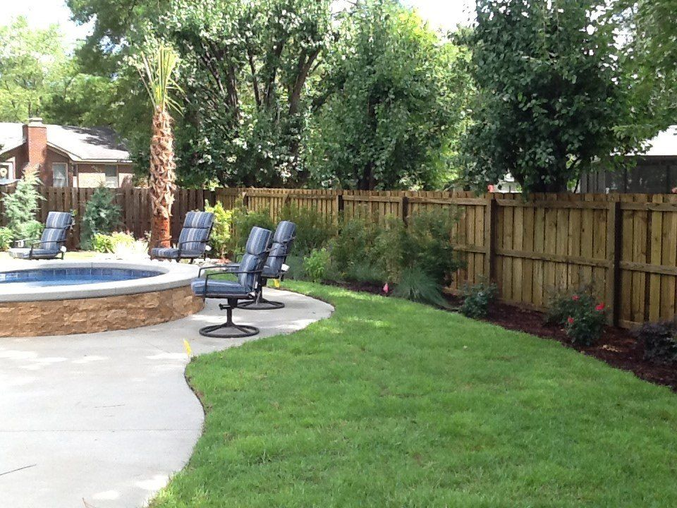 A backyard with a wooden fence and a fire pit
