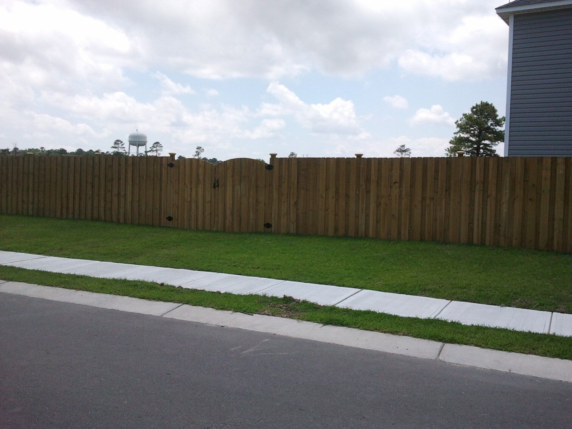 A wooden fence with a water tower in the background