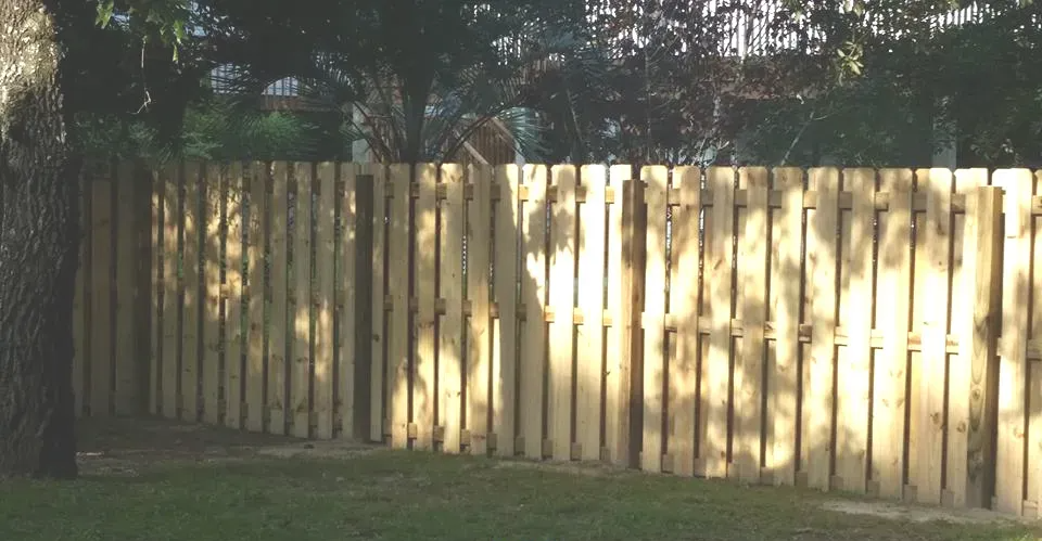 A wooden fence with trees in the background