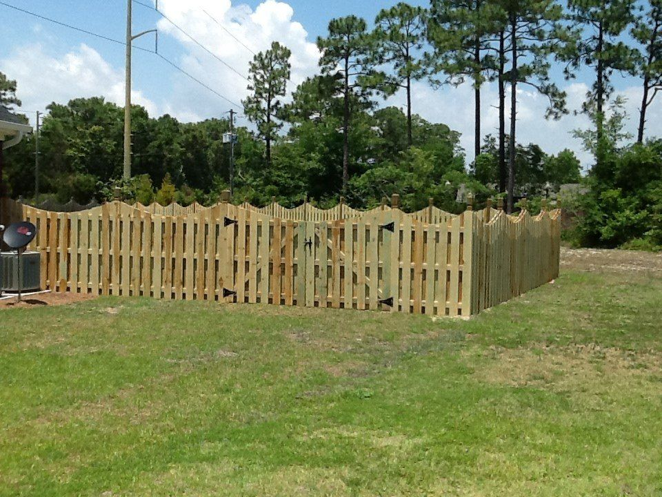 A wooden fence with a house in the background