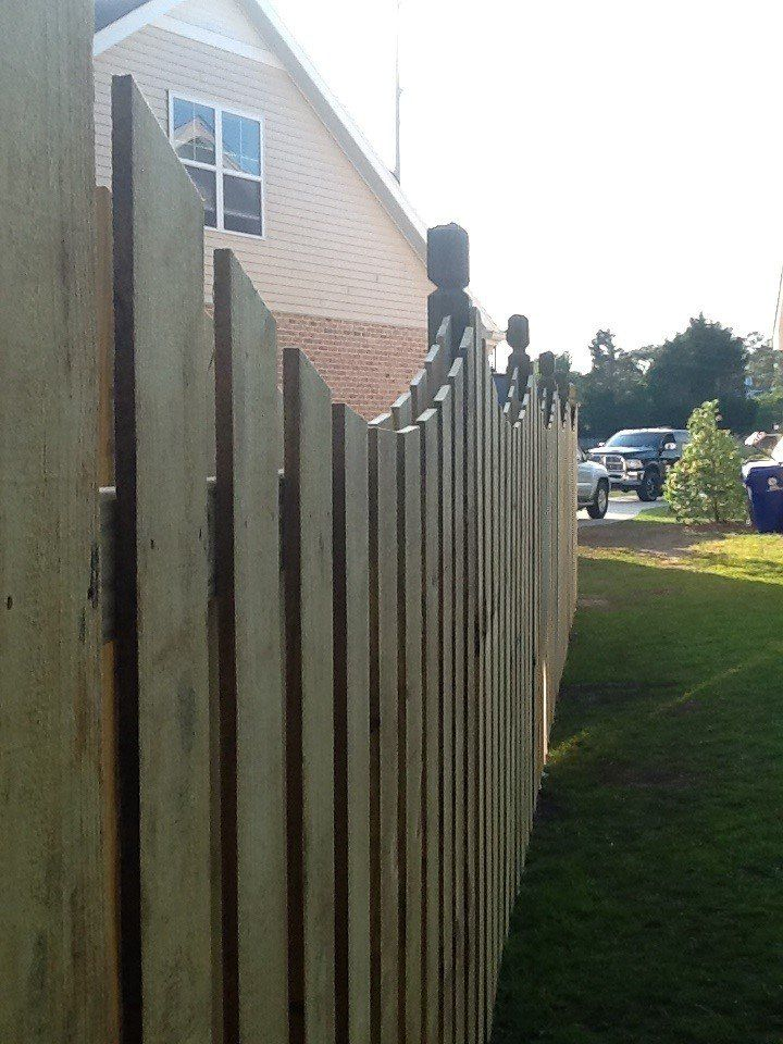 A wooden fence with a house in the background