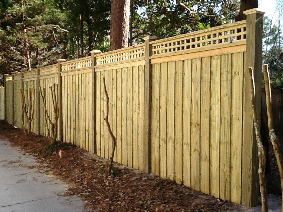 A wooden fence with a lattice on top of it