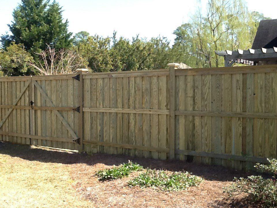 A wooden fence with a gate in the backyard