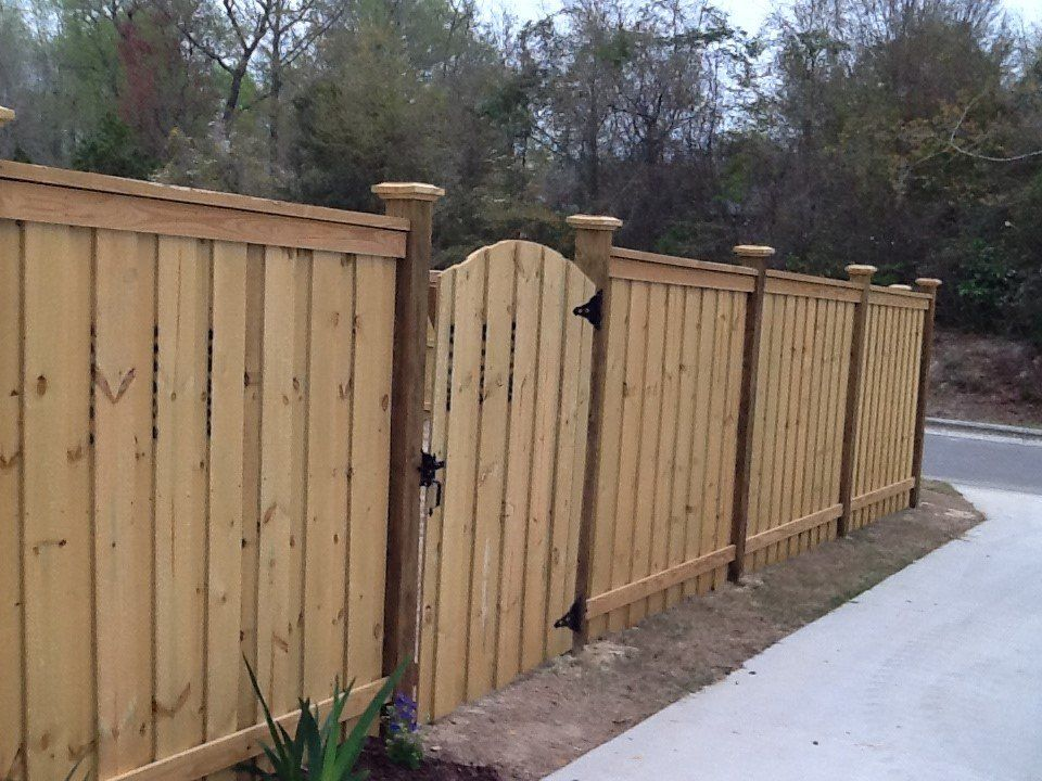 A wooden fence with a gate in the middle of it